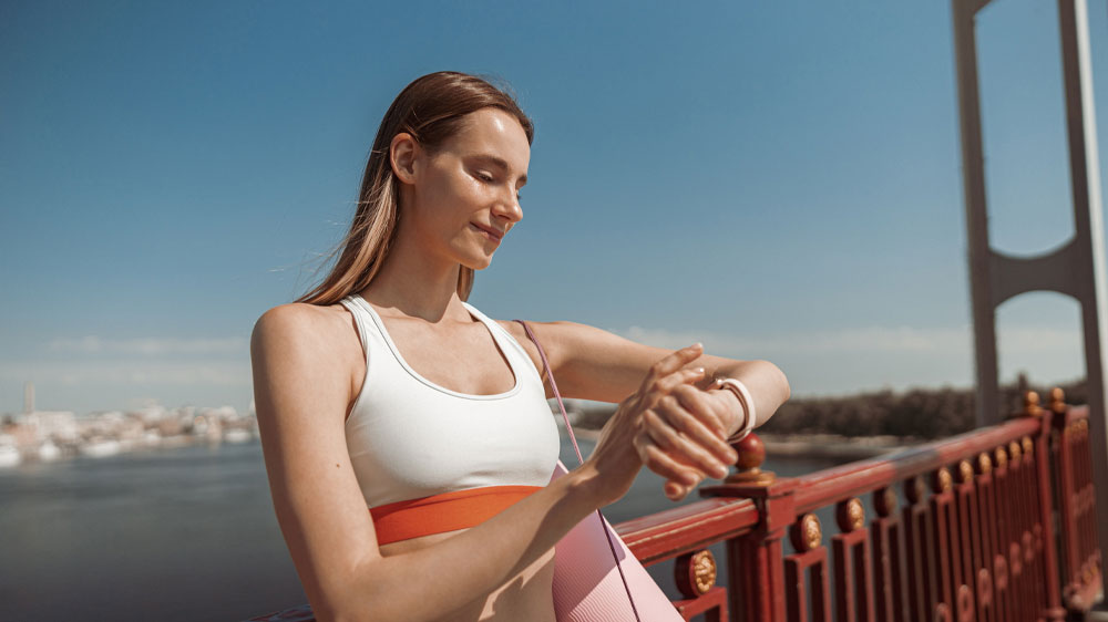 Žena na mostě hledící na chytré hodinky_02