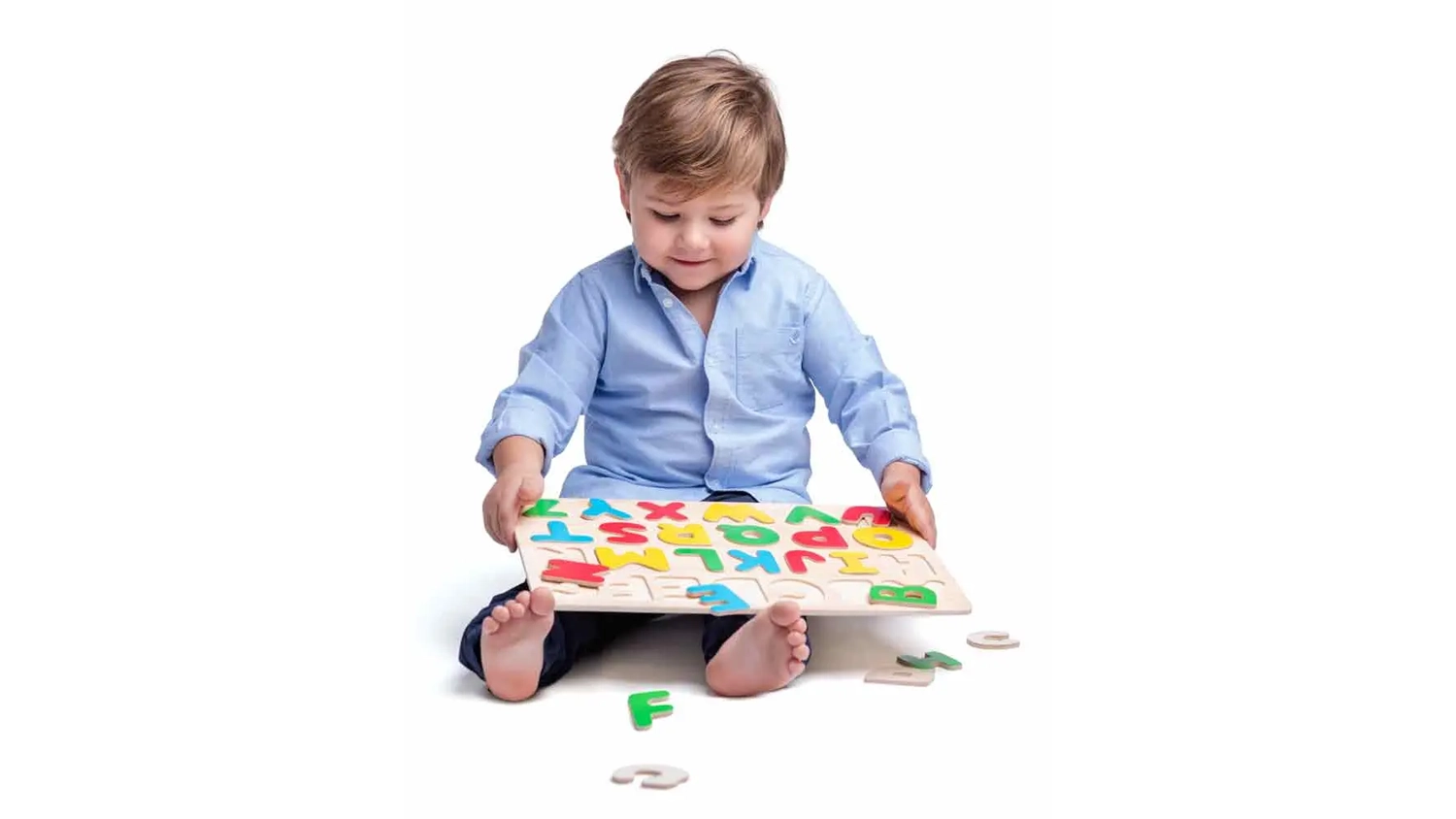 Chlapeček v modr&eacute; ko&scaron;ili si hraje s deskou a puzzl&iacute;ky