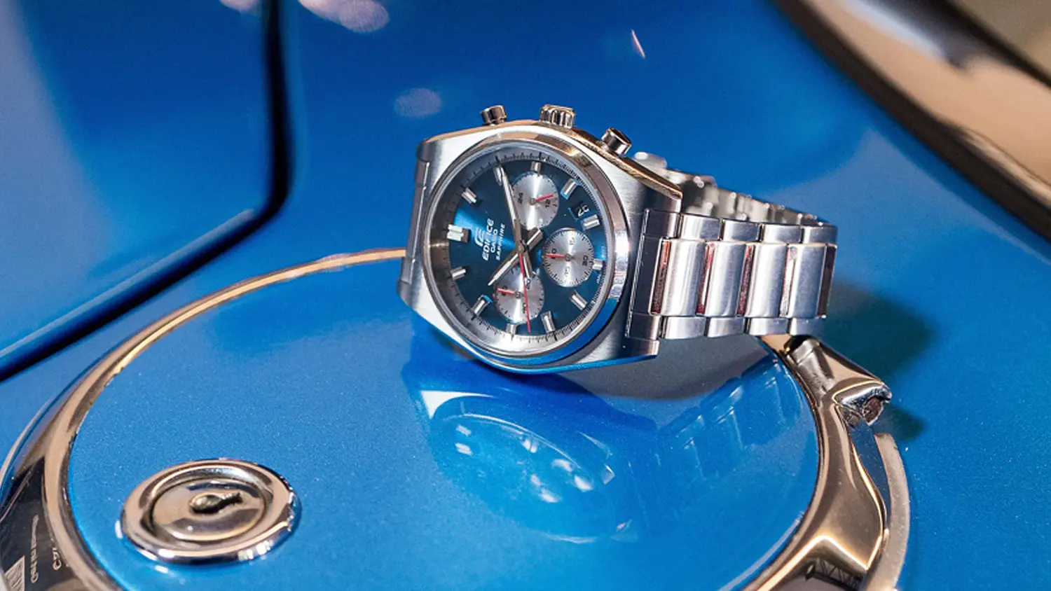 Náramkové hodinky Casio EFB-730D-2AVUEF položené na kapotě auta