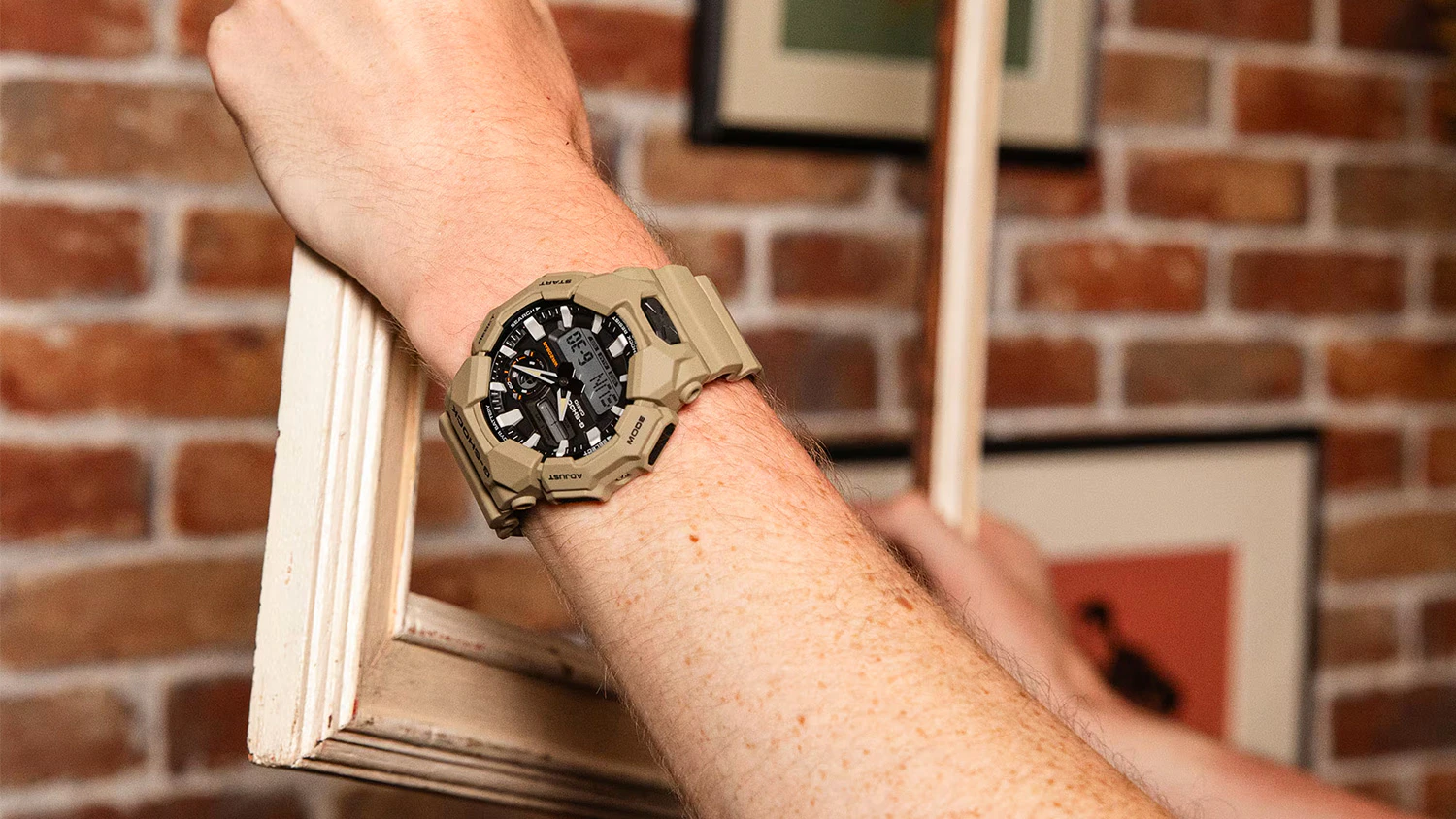 muž nasazující rám obrazu s hodinkami Casio GA-010-5AER G-SHOCK