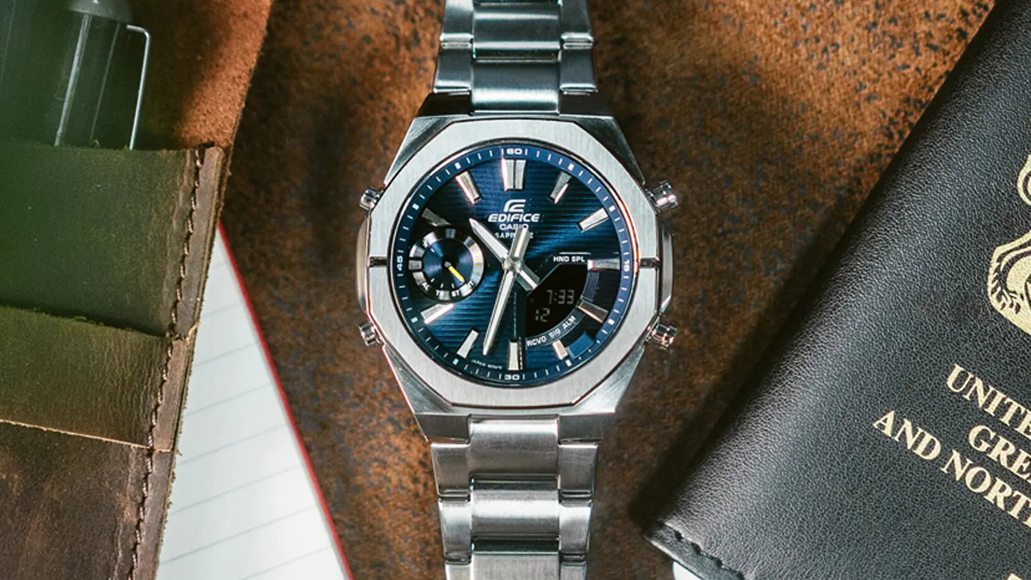 Hodinky Casio ECB-S10D-2AEF na stole vedle pasu a pera