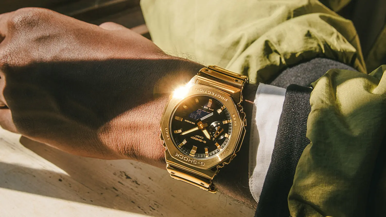 Muž m&aacute; na&nbsp;ruke n&aacute;ramkov&eacute; hodinky Casio GM-2100YMG-9AER