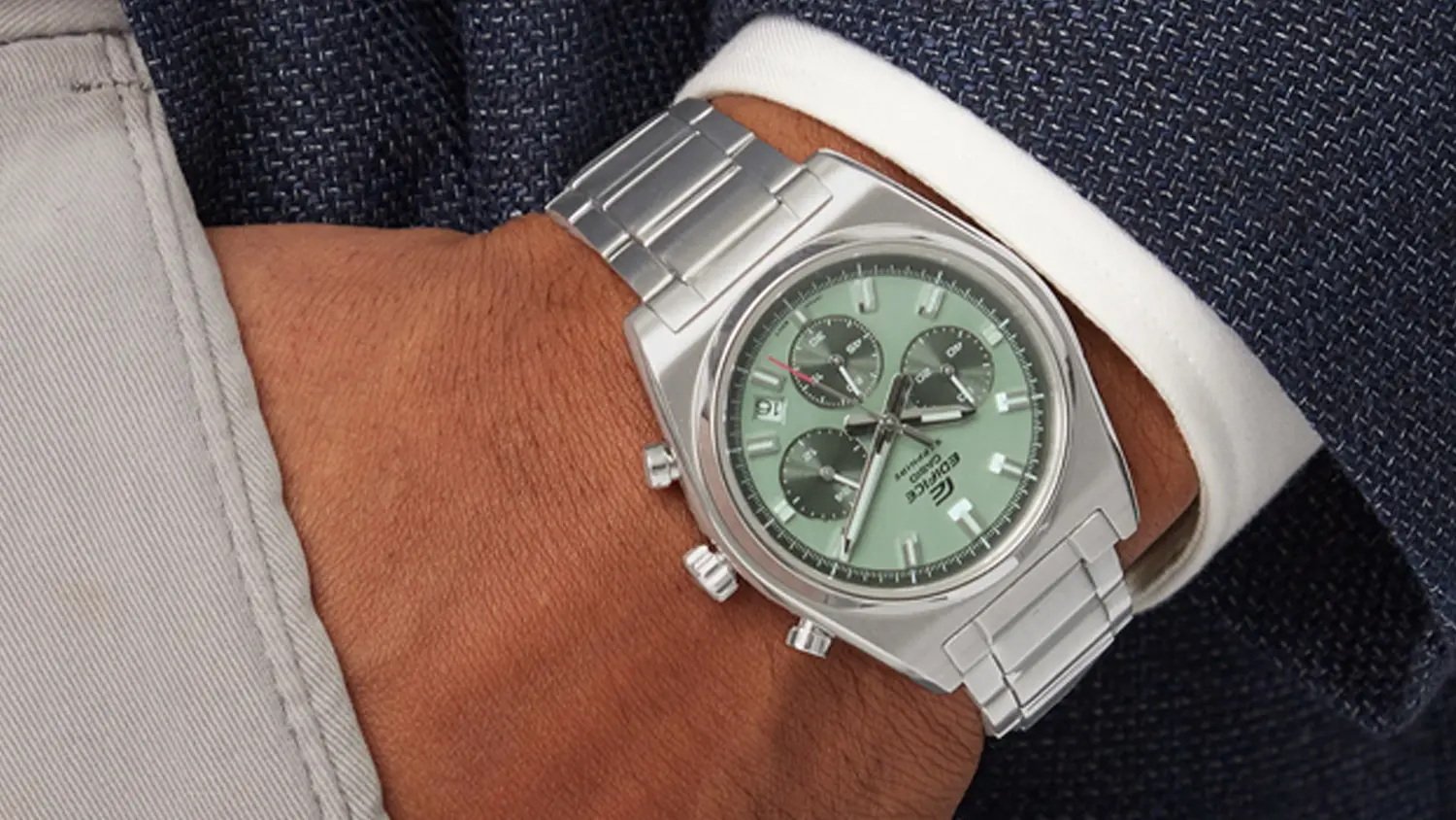 Náramkové hodinky Casio EFB-730D-3AVUEF položené na knihe s pretekmi v TV v pozadí