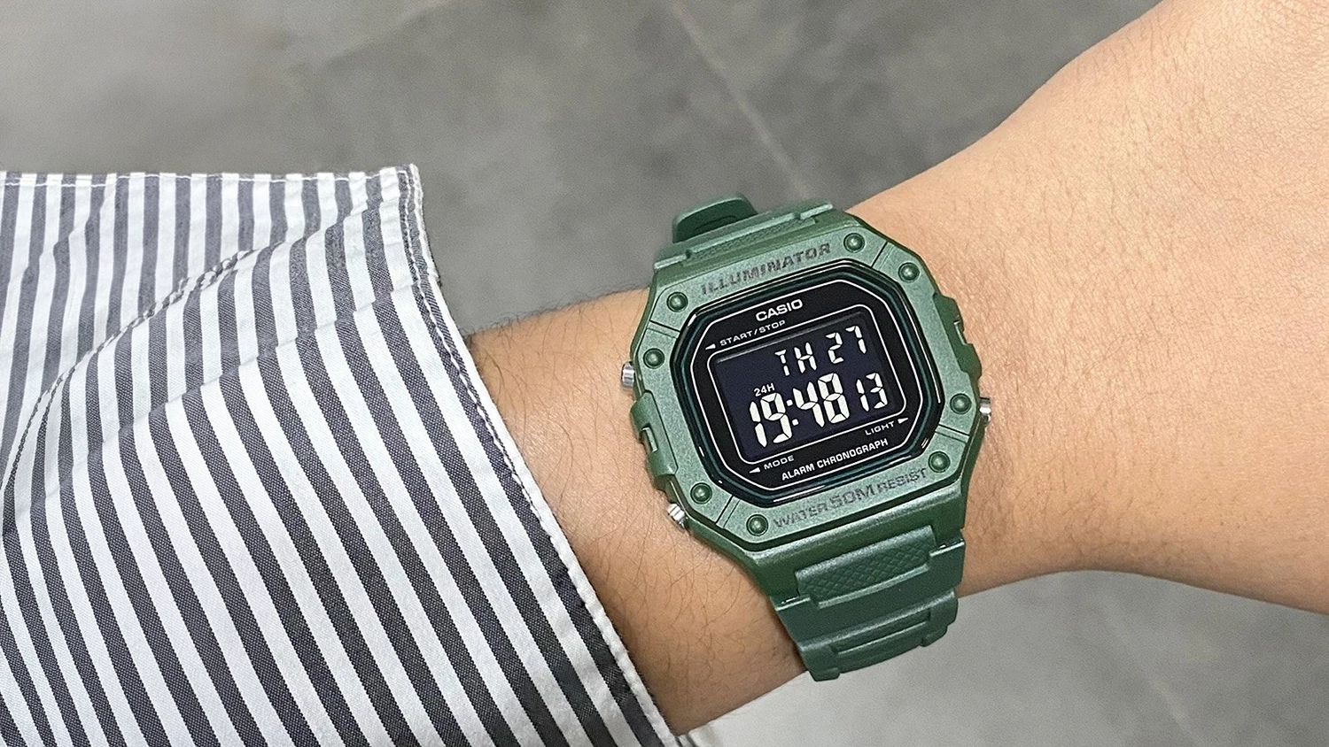 Muž ukazuje hodinky Casio W-218H-3BVEF zelen&eacute; na ruke