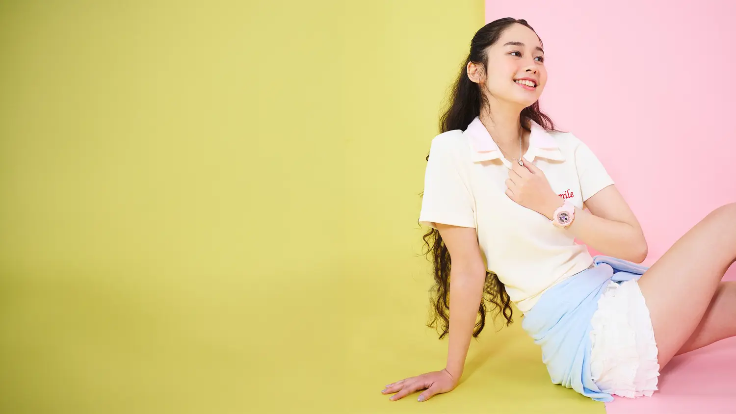 Dívka s elegantními růžovými hodinkami na zápěstí