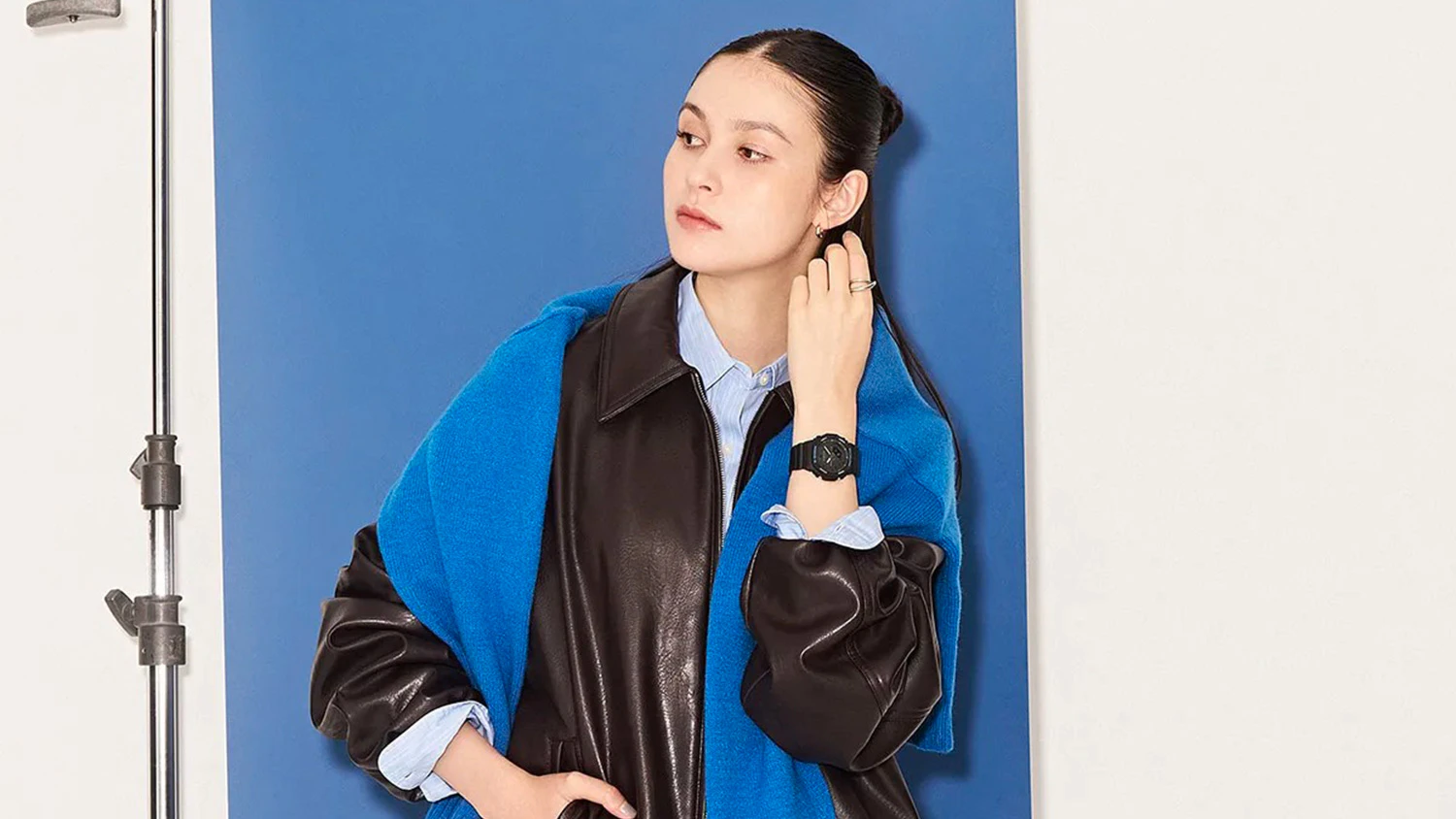 Modelka s hodinkami Casio pózuje pred modrým pozadím