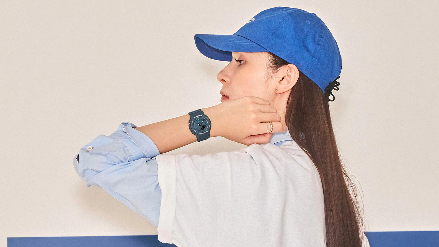 Modelka s hodinkami Casio pózuje pred modrým pozadím