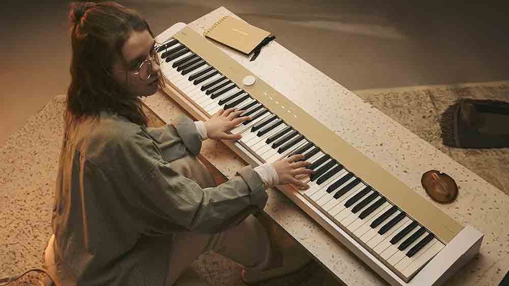 Pohled svrchu na ženu hraj&iacute;c&iacute; na digit&aacute;ln&iacute; piano Casio PX S1100 MB_05