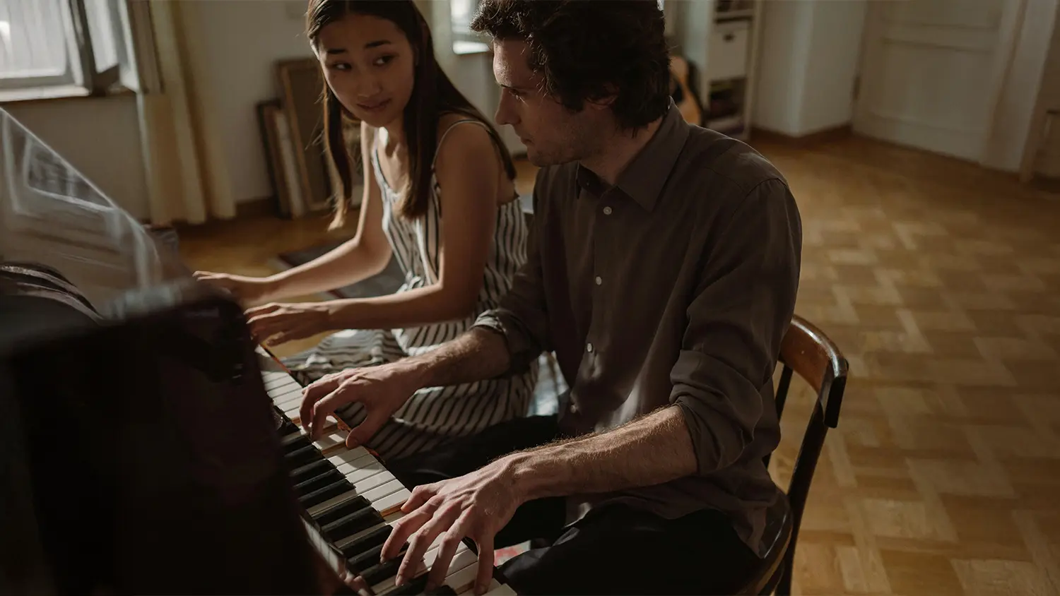 Dva lidé hrající na piano