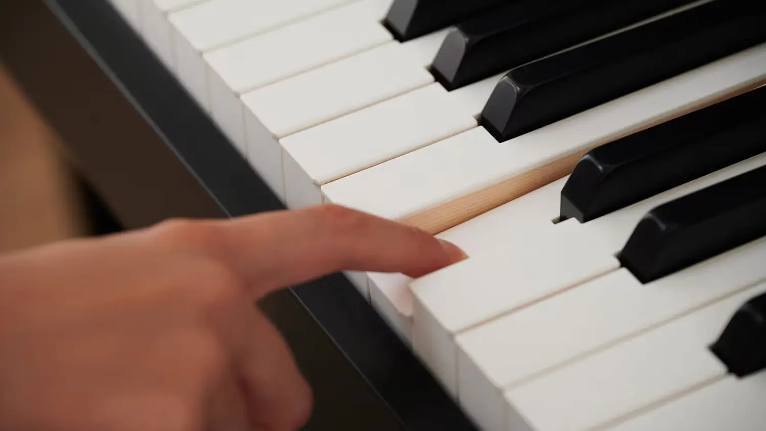Prst mačkající klávesu na digitálním pianu Casio AP 750