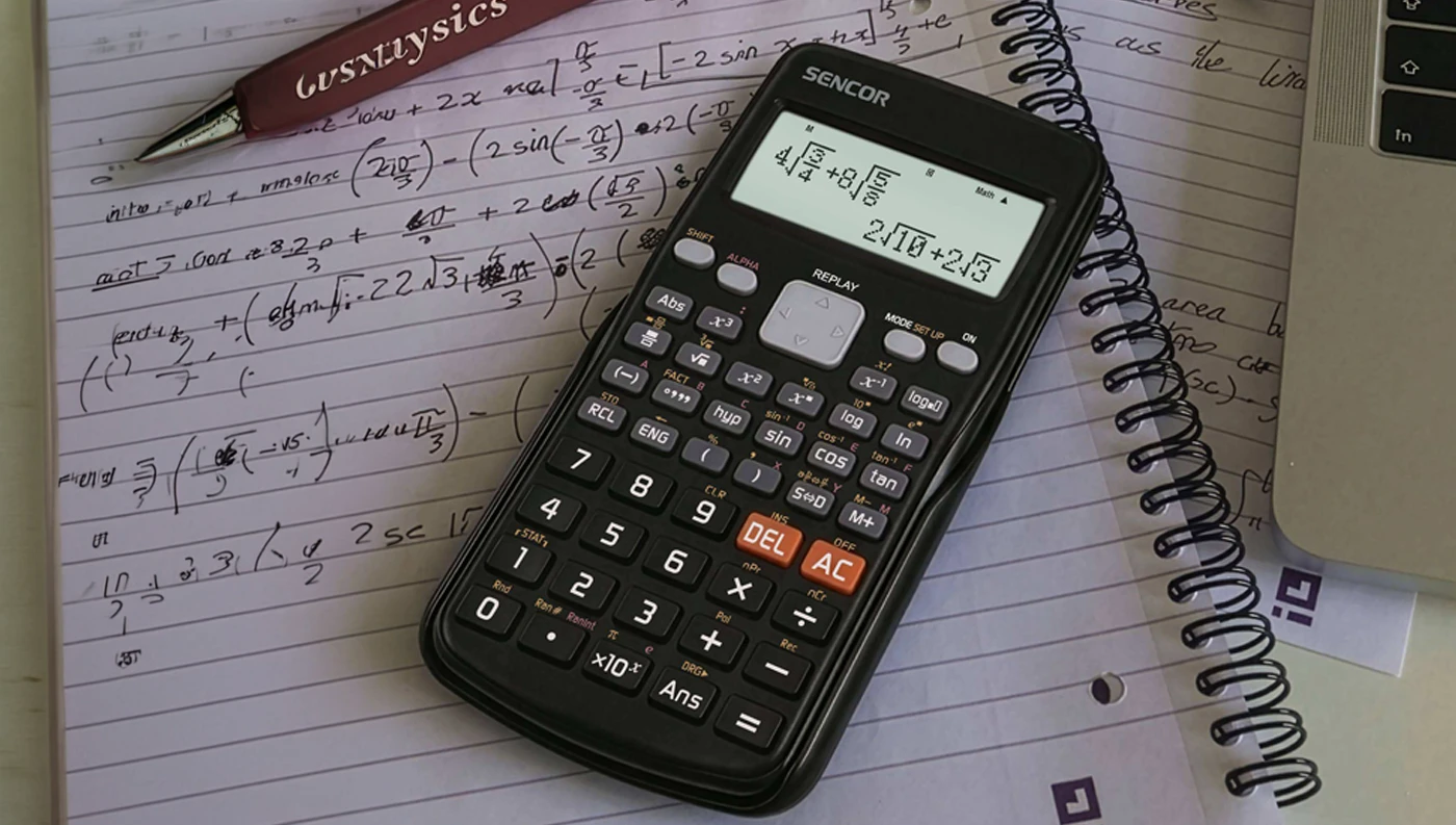 Kalkulačka SENCOR SEC 190 na stole mezi poznámkami, sešitem, perem a notebookem
