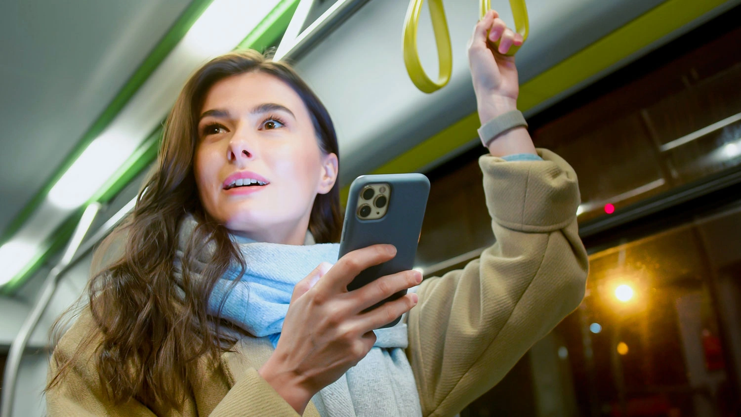 Žena v metru kouk&aacute; do mobilu.