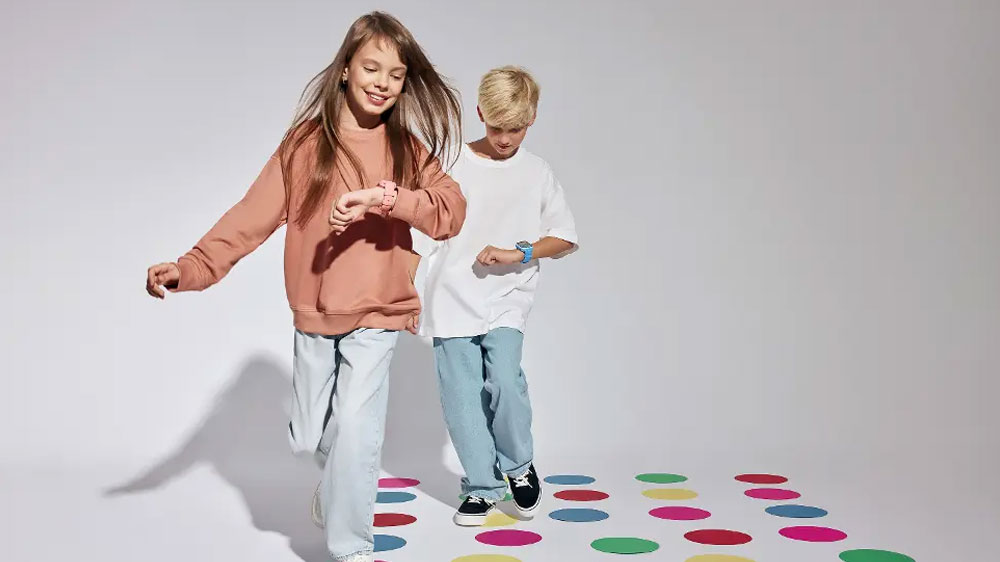 Dívka a chlapec sledující dětské chytré hodinky Garett Kids Vibe 4G nasazené na zápěstí_02