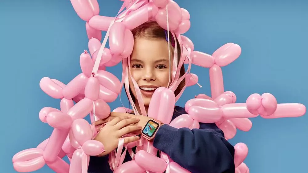 D&iacute;vka s plnou n&aacute;ruč&iacute; propleten&yacute;ch nafukovac&iacute;ch bal&oacute;nků a nasazen&yacute;mi dětsk&yacute;mi chytr&yacute;mi hodinkami Garett Kids 4K na z&aacute;pěst&iacute;_05