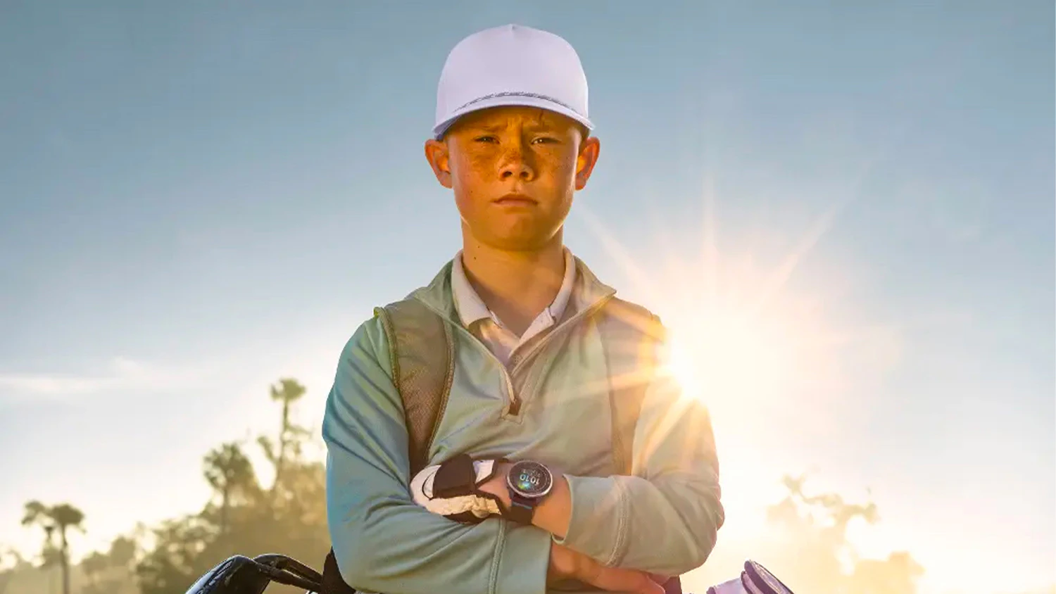 Chlapec se smart hodinkami Garmin Approach J1 ComfortFit na golfovém hřišti