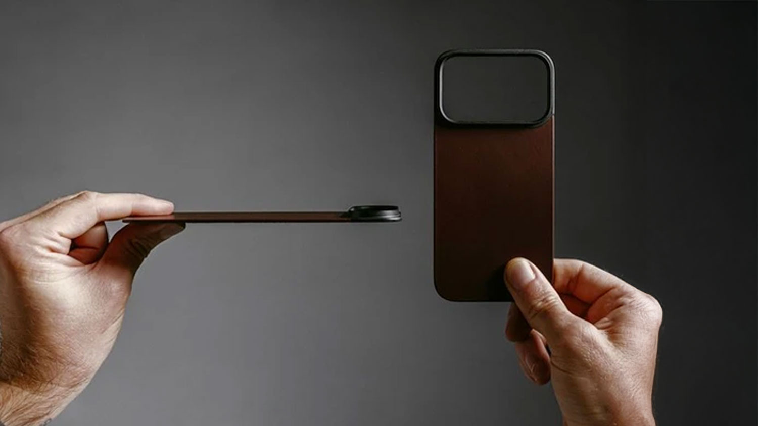 Ruka drží kryt Nomad Magnetic Leather z profilu.