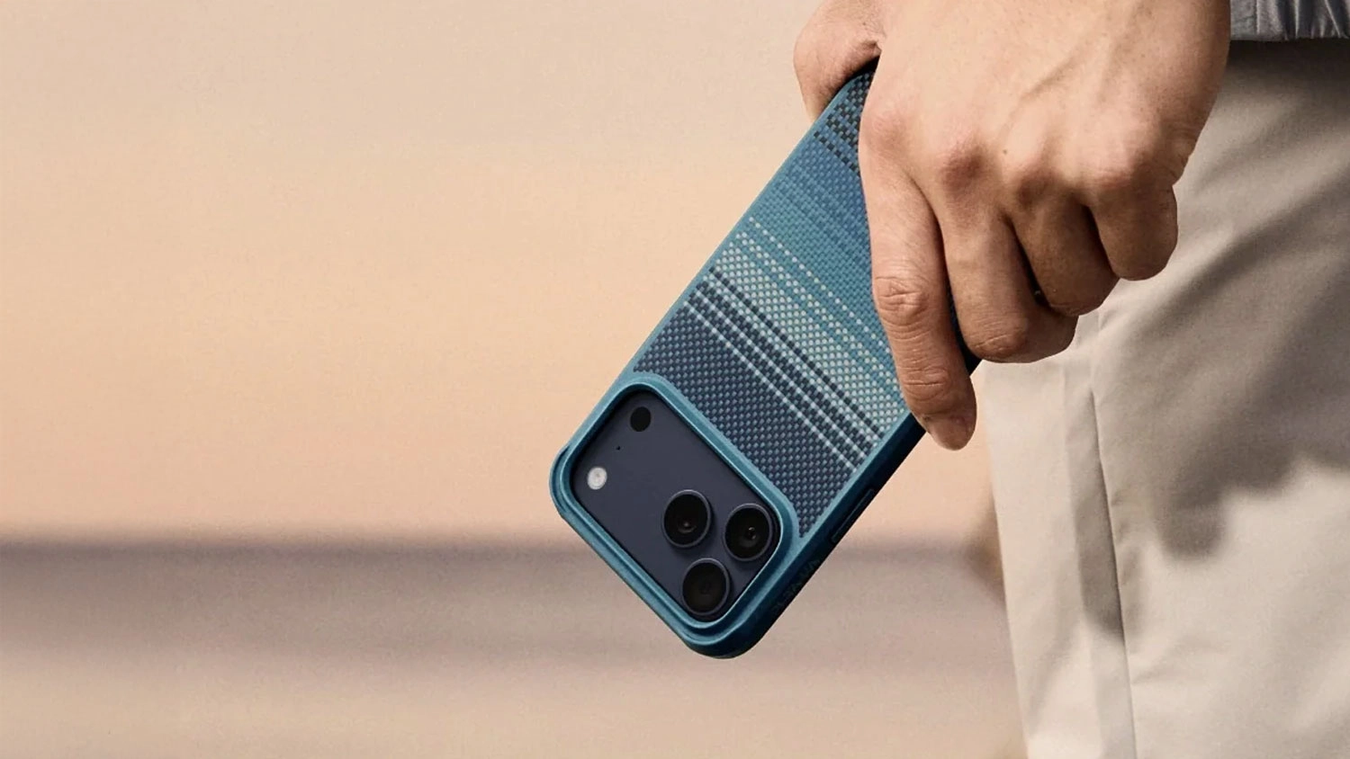 Muž drží v ruce mobil v obalu Pitaka Ultra-Slim Case.