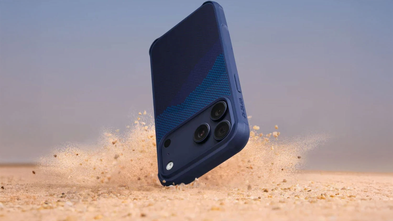 Mobil v obalu Pitaka Ultra-Slim Case při pádu do písku