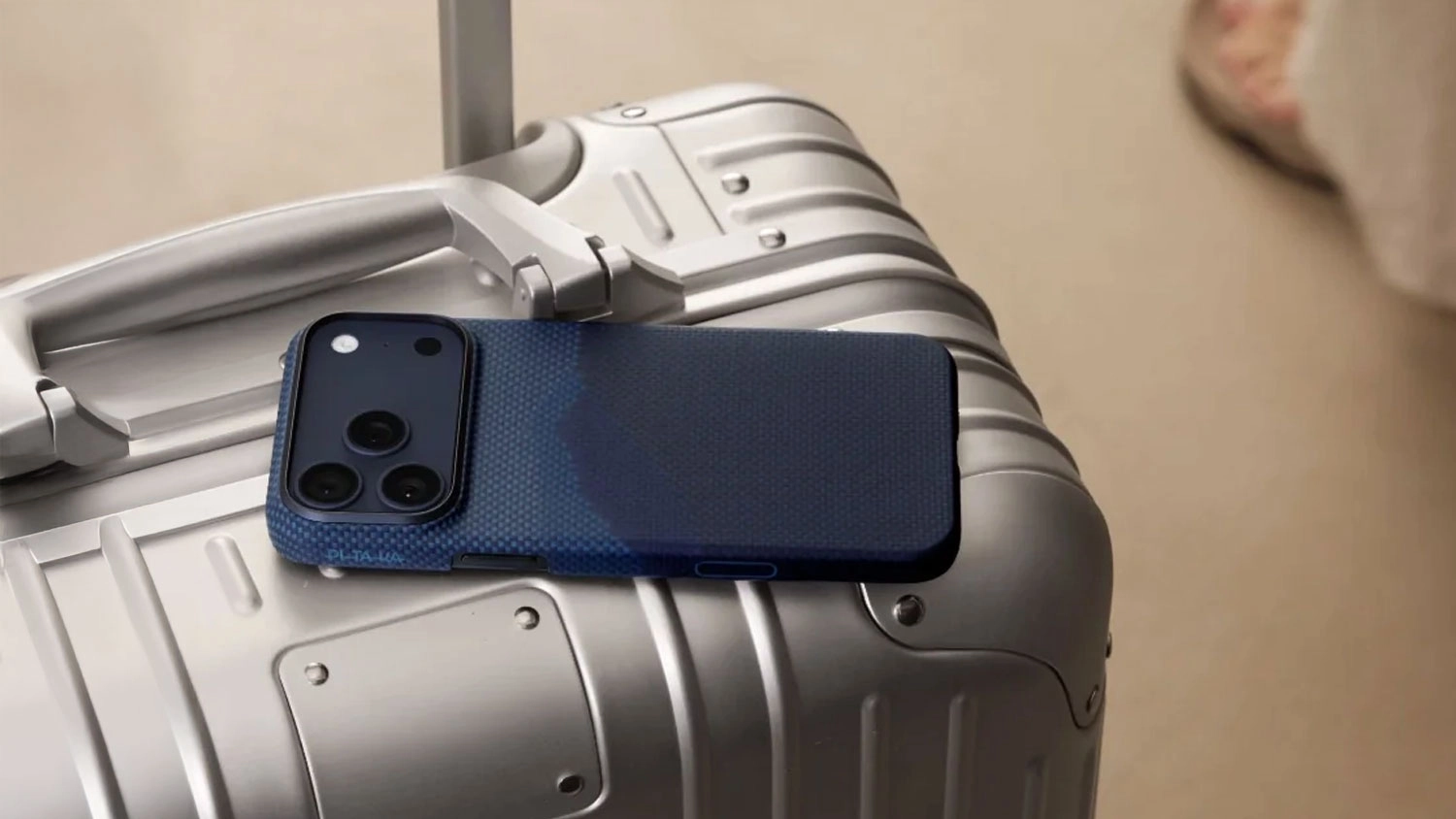 Mobil v obalu Pitaka Ultra-Slim Case položený na kufru