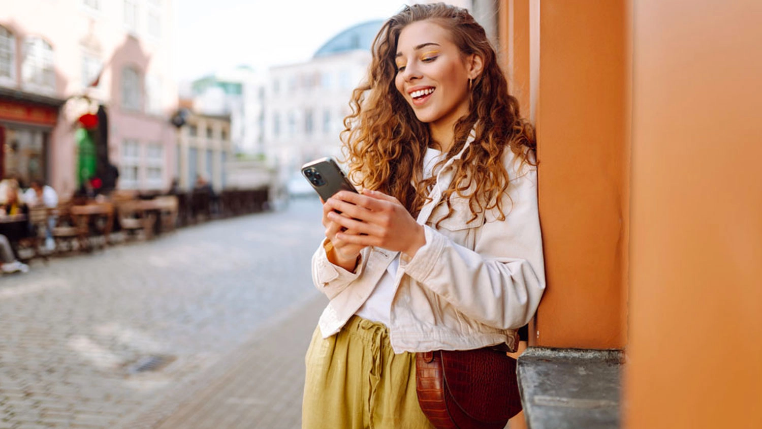 Žena drž&iacute; v ruce mobiln&iacute; telefon