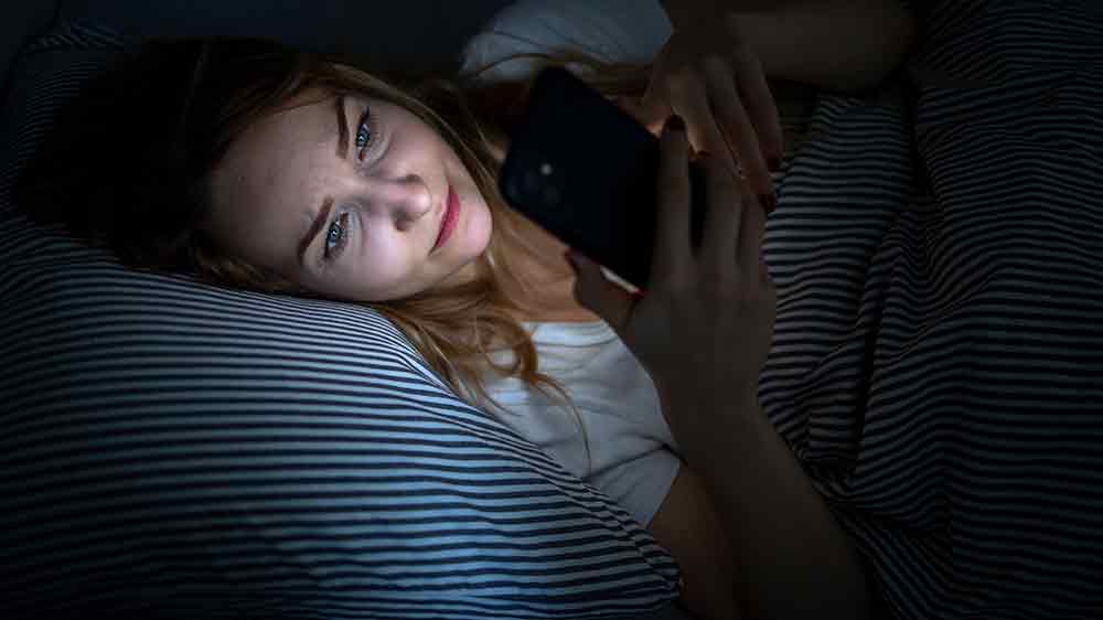 Žena, která se před spaním dívá do telefonu _06