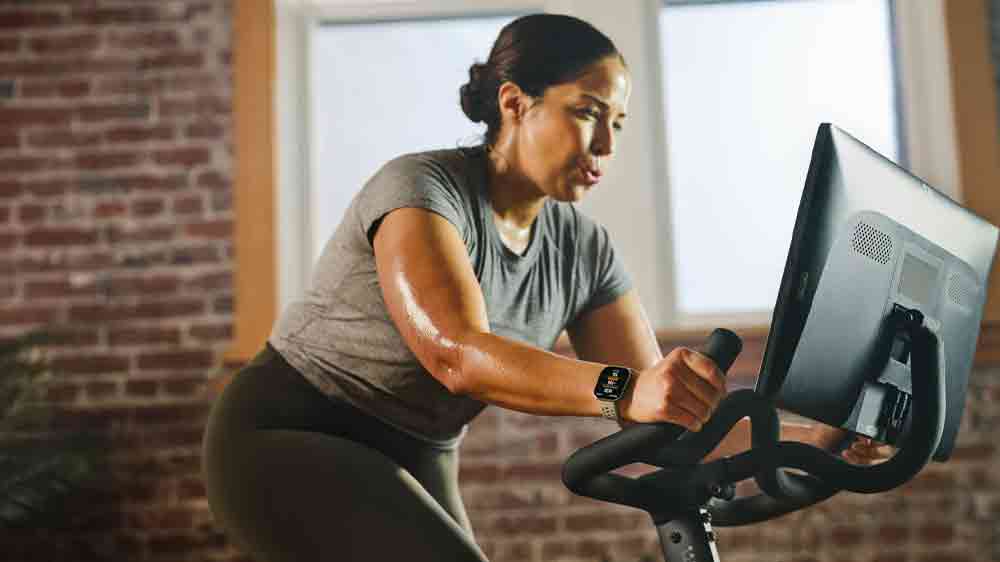 Žena s hodinkami Amazfit Bip 6 při spinningu_03