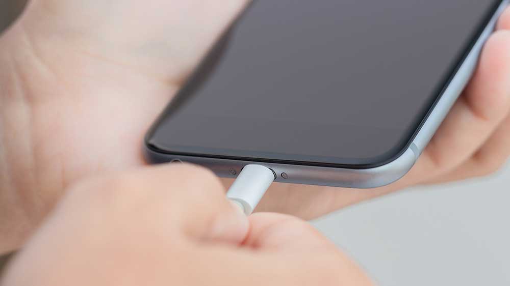 Člověk zapojuje USB-C kabel do iPhonu_02