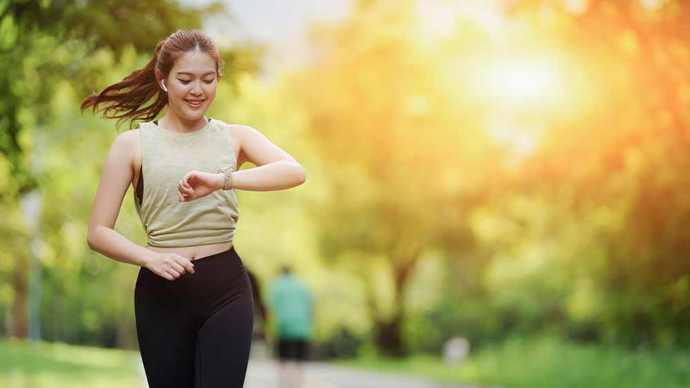 Žena běhající v parku sledující chytré hodinky na zápěstí_02