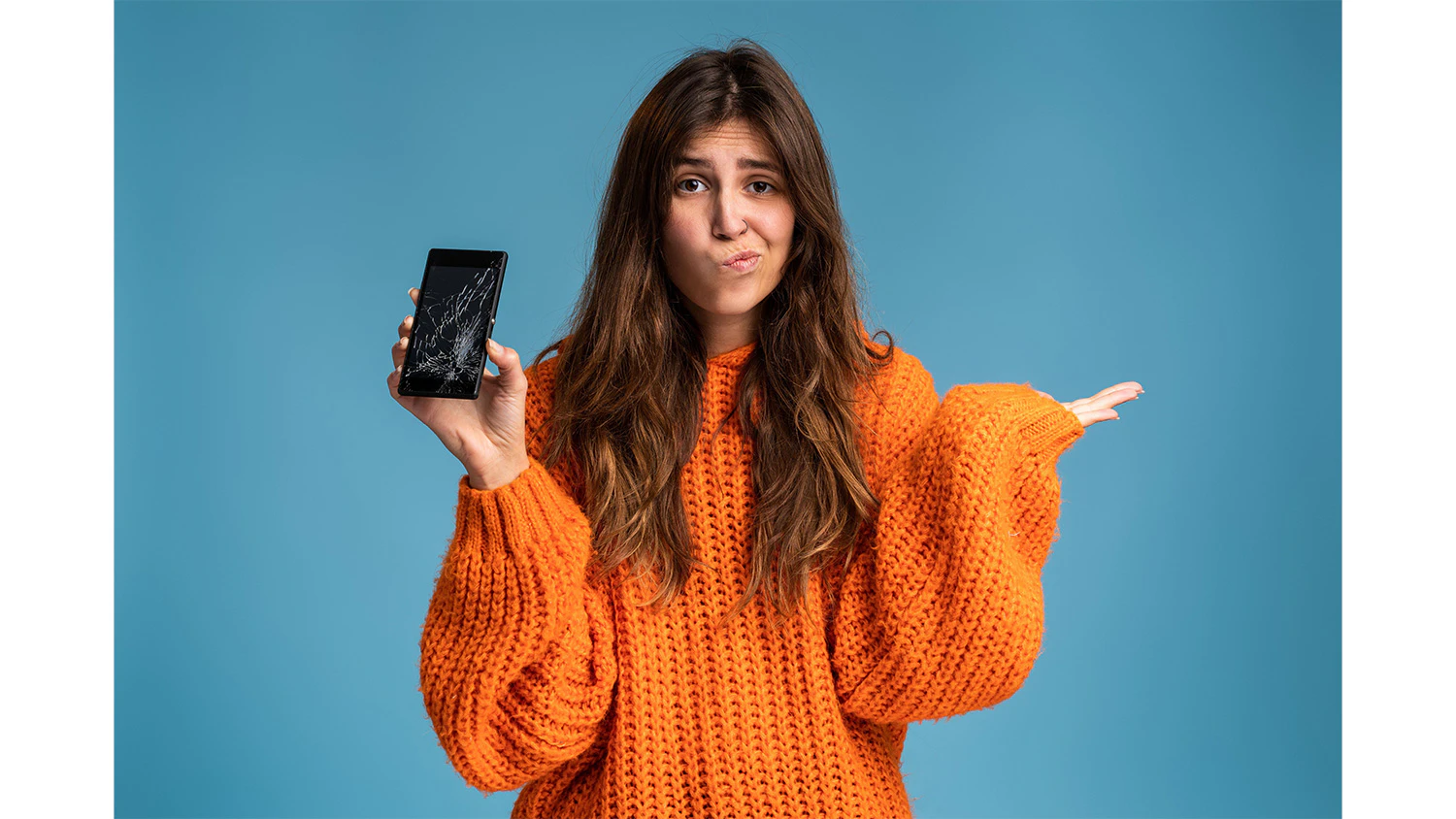 Žena, která drží v ruce rozbitý telefon