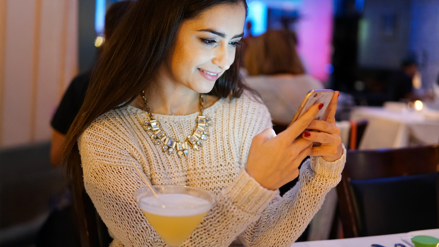 Žena v restauraci s mobilem v ruce