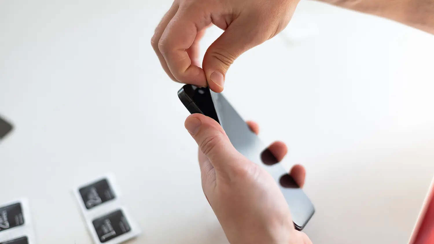 Ruka nalepuje ochrann&eacute; sklo na telefon