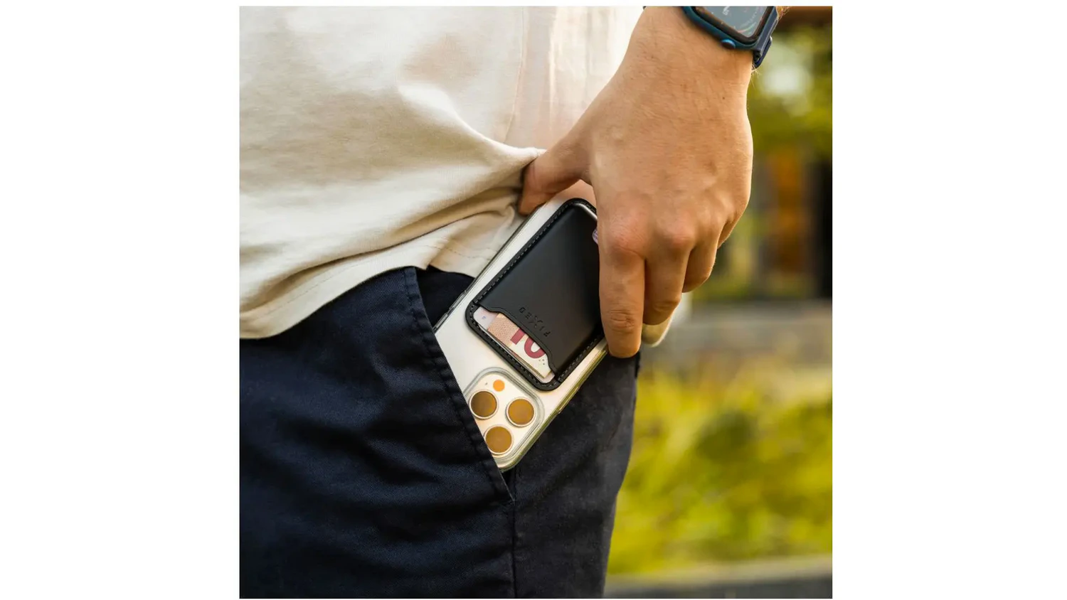 Muž drží mobil s peněženkou MagWallet a strká jej do kapsy