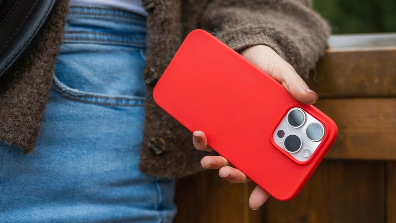 Žena drž&iacute; telefon s červen&yacute;m krytem Fixed Story