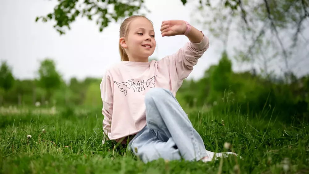Dívka hledící na hodinky SMARTWATCH GARETT KIDS NICE PRO 4G BLACK_03