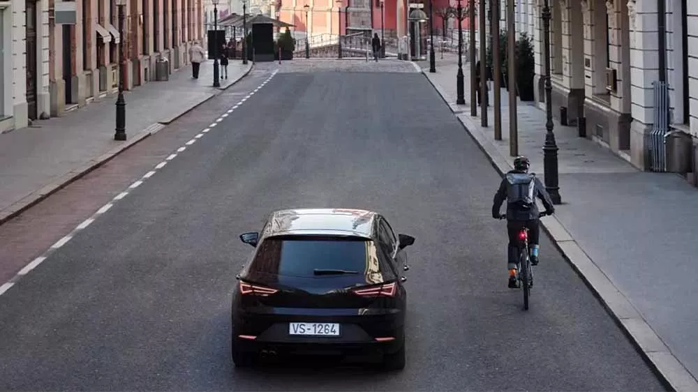 Cyklista na silnici, kolem kterého jede auto_03