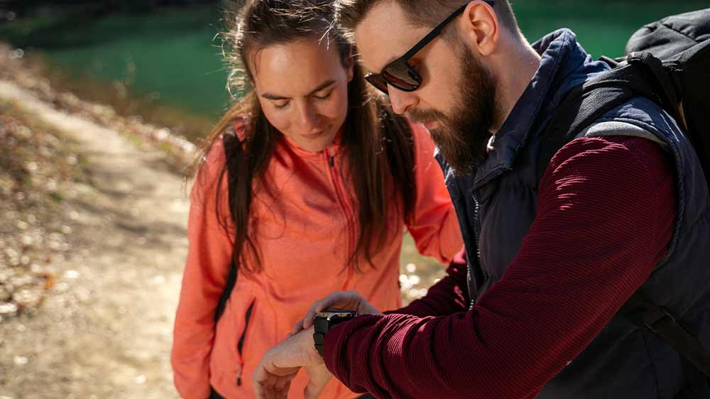 Pár kouká na chytré hodinky FENIX 7 PRO SOLAR Gray/Black Band během tracku_6