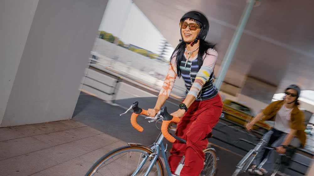 Žena a muž na kole s hodinkami Garmin Instinct 3_04