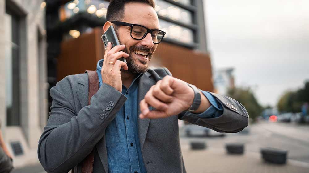Muž telefonuje a kontroluje upozornění na svých chytrých hodinkách_05
