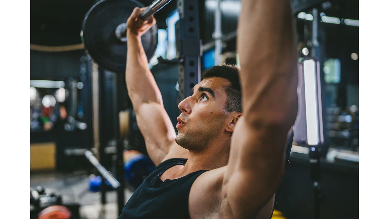 Muž zvedající činky