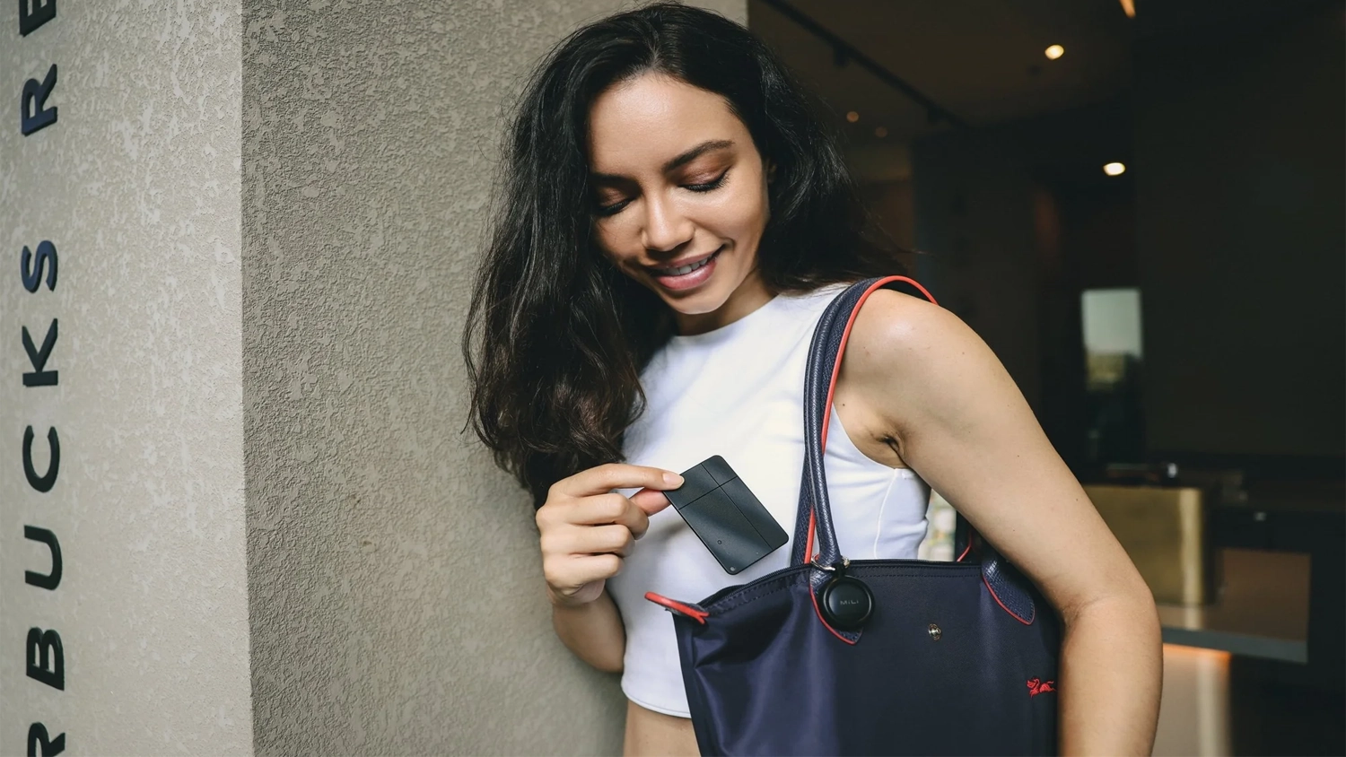 Žena dává lokátor MiLi MiCard Pro DUO do kabelky
