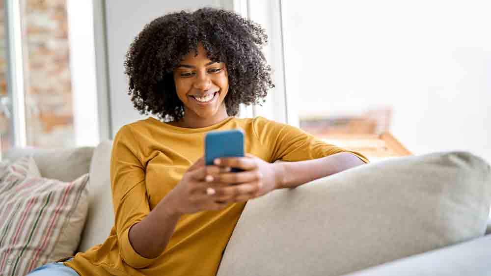 Sediaca žena sa díva do mobilného telefónu_02