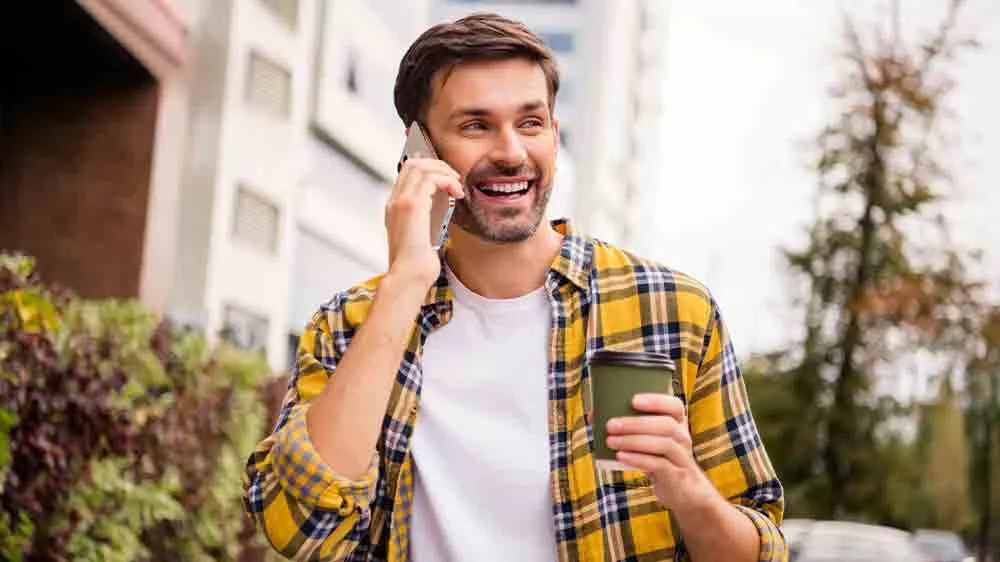 Usměvavý muž s kávou telefonuje_02