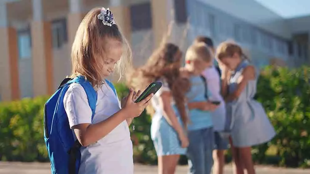 Díte s aktovkou u školy telefonuje_02