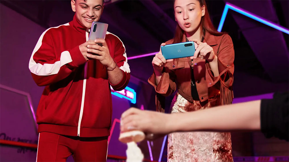 Mladík a dívka natáčí kamaráda na svém mobilním telefonu OnePlus Nord CE 5G DS