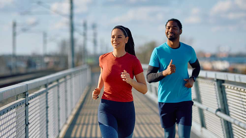 Usměvavá žena a muž s nasazeným prstenem běhají_03