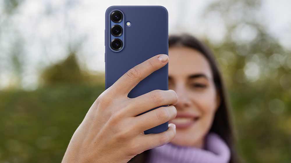 Mobilní telefon v zadním krytu Samsung Silicone Case Galaxy S25 v tmavě modré barvě v ruce dívky_02