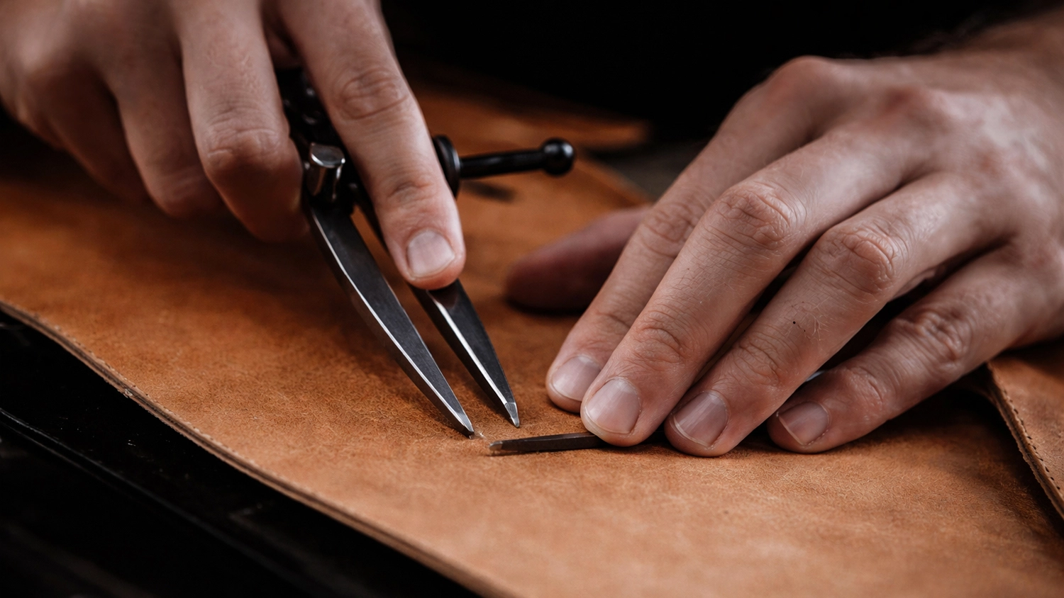 Ruce vyměřuj&iacute; kůži na v&yacute;robu řem&iacute;nku