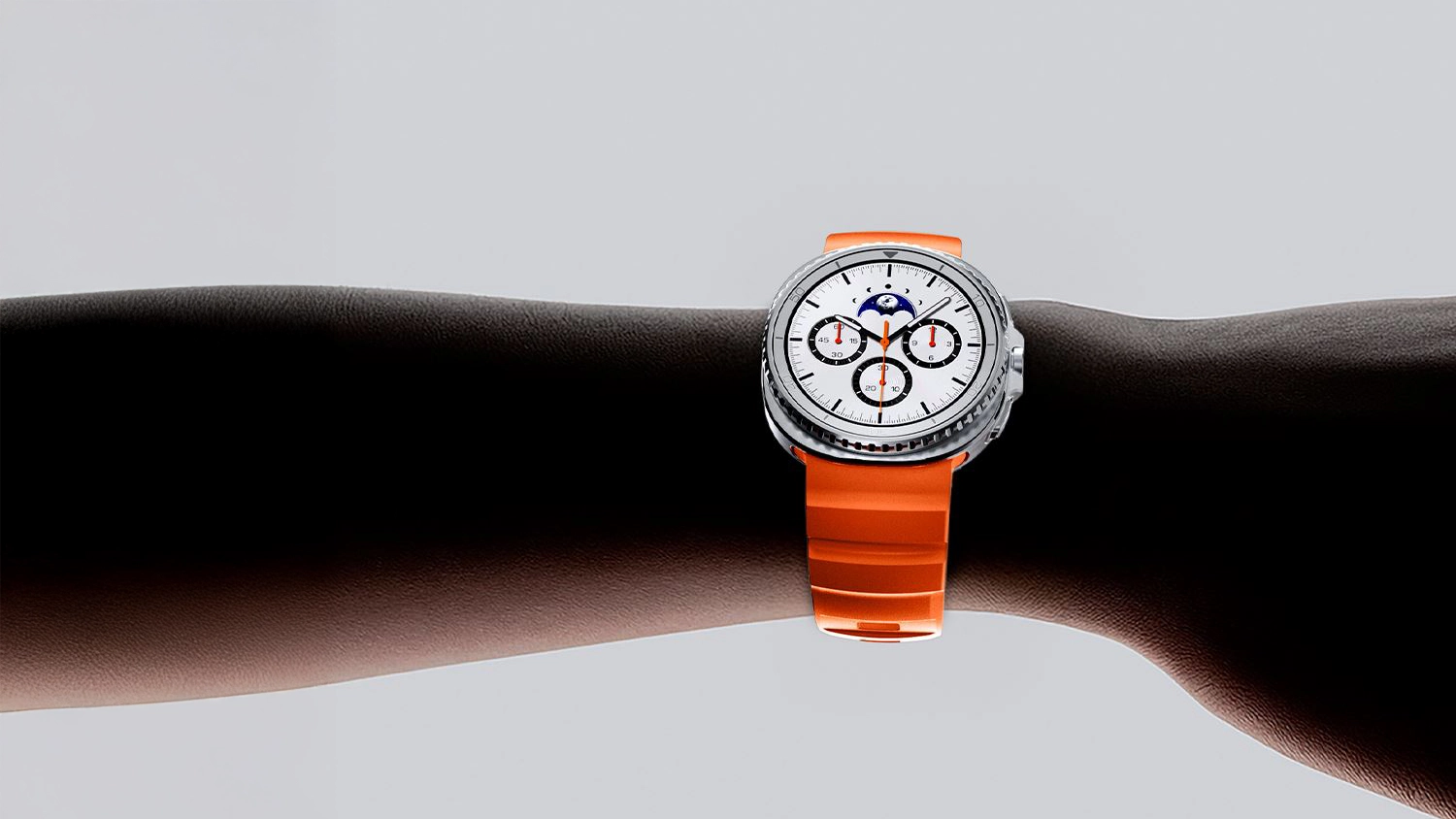 Hodinky Samsung Galaxy Watch 8 s oranžovým řemínkem na ruce
