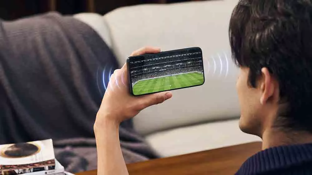 Muž sleduje fotbal na mobilním telefonu TCL 605_03