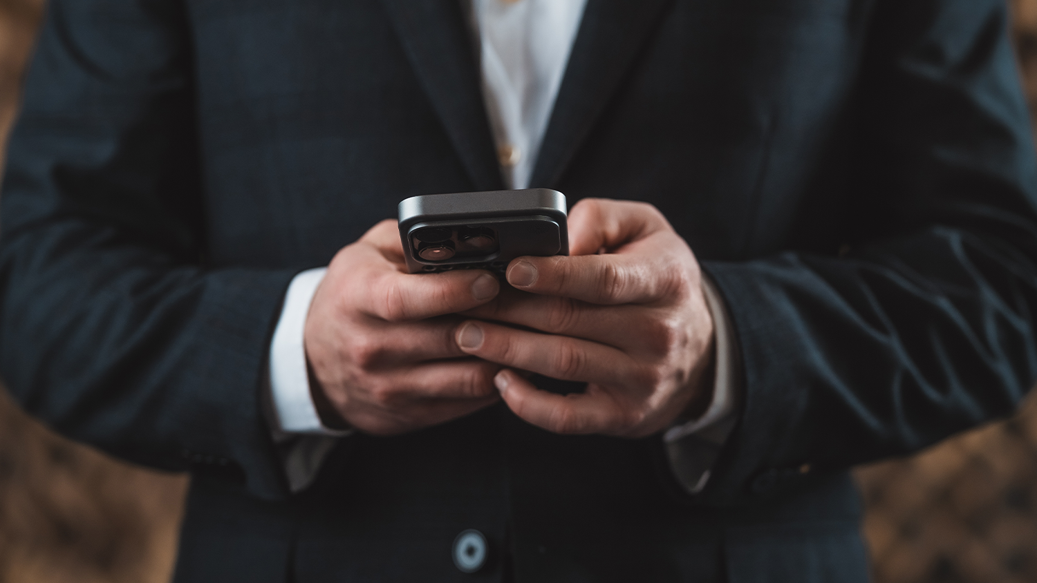 Muž drží v ruce telefon v krytu